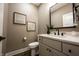 Modern half bathroom with a stylish vanity, dark hardware, decorative mirror and neutral wall color at 3899 Chapel Hill Ct, Bargersville, IN 46106