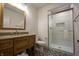 Bright bathroom featuring a framed mirror, vanity sink, and glass shower with patterned floor at 3899 Chapel Hill Ct, Bargersville, IN 46106