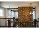 Open foyer with brick accent wall, iron and wood railing, and hanging light fixtures at 3899 Chapel Hill Ct, Bargersville, IN 46106