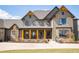 Elegant two-story home featuring a covered porch with seating and beautifully landscaped grounds at 3899 Chapel Hill Ct, Bargersville, IN 46106