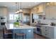 A modern kitchen featuring gray cabinetry, stainless steel appliances, and a large island with bar seating at 3899 Chapel Hill Ct, Bargersville, IN 46106