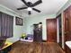Bedroom with wooden floor, ceiling fan, fish tank, and sage green walls at 3949 Fletcher Ave, Indianapolis, IN 46203