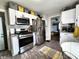 Bright kitchen features stainless steel appliances, modern white cabinets, and wood-look floors at 3949 Fletcher Ave, Indianapolis, IN 46203