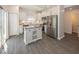 Bright kitchen features white cabinets, stainless steel appliances, gray wood floor, and center island at 4363 Rhapsody Ln, Indianapolis, IN 46235