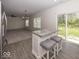 Open living space features neutral paint, gray carpet, large windows, access to yard, and modern light fixture at 4363 Rhapsody Ln, Indianapolis, IN 46235