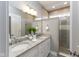 Modern bathroom features a double vanity with granite countertops and glass-enclosed shower at 445 W 86Th St, Indianapolis, IN 46260