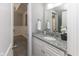 Bathroom featuring a granite countertop, large mirror, and tiled floors at 445 W 86Th St, Indianapolis, IN 46260