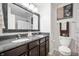 Bathroom with double sinks, framed mirror, granite countertop, and modern fixtures at 4846 Shakamak Ct, Indianapolis, IN 46239