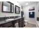 Well-lit bathroom features double sinks, dark cabinetry, and modern fixtures and décor at 4846 Shakamak Ct, Indianapolis, IN 46239