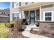 Inviting front porch with brick accents, a decorative door, and a landscaped garden at 4846 Shakamak Ct, Indianapolis, IN 46239
