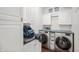 Functional laundry room with white cabinetry, counter space, and modern washer and dryer units for efficient chores at 4846 Shakamak Ct, Indianapolis, IN 46239