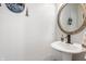 Simple and elegant powder room with a pedestal sink, decorative mirror, and welcoming decor at 4846 Shakamak Ct, Indianapolis, IN 46239