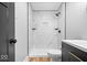 Bathroom showcasing white tiled shower, dark fixtures, floating shelves, and contrasting door at 4921 Cottonwood N Ct, Columbus, IN 47203