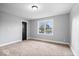 Bedroom with neutral carpet, grey walls, and large window, complemented by a dark door at 4921 Cottonwood N Ct, Columbus, IN 47203