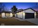 Charming home featuring modern black and white accents, attached garage, and well-manicured lawn at 4921 Cottonwood N Ct, Columbus, IN 47203
