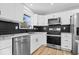 Modern kitchen featuring stainless steel appliances, subway tile backsplash, granite countertops, and white cabinets at 4921 Cottonwood N Ct, Columbus, IN 47203