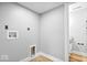Bright laundry room with connections, wood-look floors, and white walls, offering practicality at 4921 Cottonwood N Ct, Columbus, IN 47203