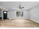Inviting living room with large window, neutral walls, wood floors, and ceiling fan at 4921 Cottonwood N Ct, Columbus, IN 47203