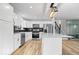 Open-concept kitchen with white cabinetry, black backsplash, and living area with natural light at 4921 Cottonwood N Ct, Columbus, IN 47203