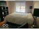 Cozy bedroom featuring a queen size bed, bedside lamps, and a window at 5347 N College Ave # Apt 109, Indianapolis, IN 46220
