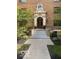 Elegant building entrance with decorative stonework, fresh landscaping, and potted plants at 5347 N College Ave # Apt 109, Indianapolis, IN 46220