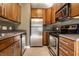 Efficient kitchen featuring stainless steel appliances, wood cabinetry, and durable countertops at 5347 N College Ave # Apt 109, Indianapolis, IN 46220