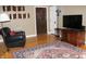 Cozy living room featuring hardwood floors, a decorative rug, and TV entertainment area at 5347 N College Ave # Apt 109, Indianapolis, IN 46220