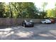 View of parking lot with designated parking spots, surrounded by a wooden fence, and trees at 5347 N College Ave # Apt 109, Indianapolis, IN 46220