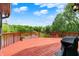 Lovely back deck with wood railing overlooks lush green trees and a serene lake view at 5571 Poff Rd, Martinsville, IN 46151