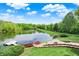 Serene backyard with lake access, featuring a stone patio and manicured lawn at 5571 Poff Rd, Martinsville, IN 46151
