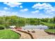 Backyard with stone patio, fire pit, and a serene view of the lake and lush greenery at 5571 Poff Rd, Martinsville, IN 46151