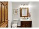 Charming half-bath with a vessel sink, wood-framed mirror, and decorative floral artwork at 5571 Poff Rd, Martinsville, IN 46151