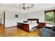 Spacious bedroom featuring hardwood floors, a ceiling fan, and large window with wooded views at 5571 Poff Rd, Martinsville, IN 46151