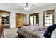 Bedroom featuring a ceiling fan, multiple windows with trim, and a door to a patio with stone features at 5571 Poff Rd, Martinsville, IN 46151