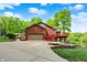 Brick home with a concrete driveway, and a large garage facing a lake in the background at 5571 Poff Rd, Martinsville, IN 46151