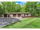 Exterior view of property with multiple garage doors, a deck, landscaping and surrounding trees at 5571 Poff Rd, Martinsville, IN 46151