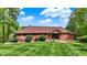 Well-maintained brick home with a lush lawn, enhanced by scenic landscaping and manicured shrubbery at 5571 Poff Rd, Martinsville, IN 46151