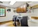 Modern laundry room with hardwood floors, a utility sink, and front load washer and dryer at 5571 Poff Rd, Martinsville, IN 46151