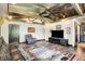 Living room with a rustic ceiling, leather seating, wood floors, and entertainment area with a TV at 5571 Poff Rd, Martinsville, IN 46151