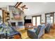 Stunning living room with stone fireplace, wood floors, ceiling fan, and comfortable leather seating at 5571 Poff Rd, Martinsville, IN 46151
