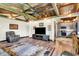 Open living room with vaulted ceiling, wood beams, ceiling fan and wood floors at 5571 Poff Rd, Martinsville, IN 46151