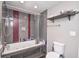 Bathroom showcasing a tub with shower, gray tile and a comfort height toilet at 601 Terrace Lake Dr, Columbus, IN 47201