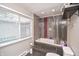 Bathroom featuring a large tub and shower combo with grey tile and a window at 601 Terrace Lake Dr, Columbus, IN 47201