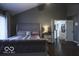 Bedroom with a tufted headboard, hardwood floors, and ensuite access at 6019 Timberbend Dr, Avon, IN 46123