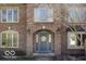 Charming brick home featuring a blue front door with a decorative wreath and arched entryway at 6019 Timberbend Dr, Avon, IN 46123