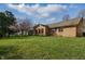 Expansive backyard showcasing the home's brick exterior and a well-maintained lawn under a sunny sky at 6140 Buttonwood Dr, Noblesville, IN 46062