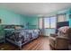 Tranquil bedroom with teal walls, patterned bedding, and large window for natural light at 6140 Buttonwood Dr, Noblesville, IN 46062