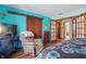 Cozy bedroom with hardwood floors, aqua walls, and a comfortable armchair, creating a relaxing retreat at 6140 Buttonwood Dr, Noblesville, IN 46062