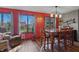 Open dining area with large windows, hardwood floors, and red accent wall at 6140 Buttonwood Dr, Noblesville, IN 46062