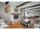 Cozy living room with white brick fireplace, wood beam ceiling, and natural wood flooring at 6140 Buttonwood Dr, Noblesville, IN 46062